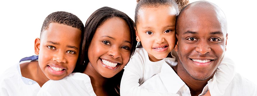 Family of four in white in front of white background smiling