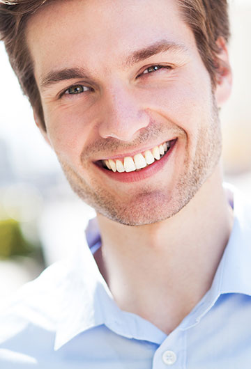 Man smiling in light blue button-up shirt