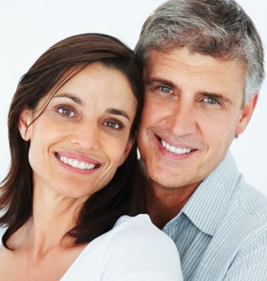 Couple in their 50s smiling and embracing