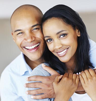 Couple embracing and smiling at the camera