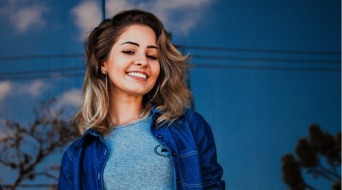 girl smiling wearing a jean jacket 