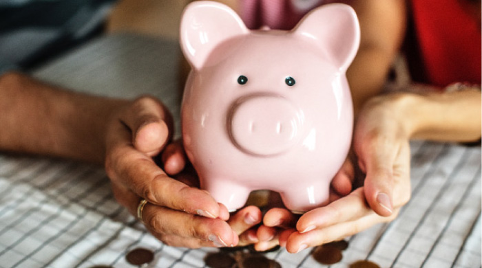 pink piggybank spilling coins out of the bottom