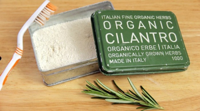 tin of organic toothpaste with a toothbrush