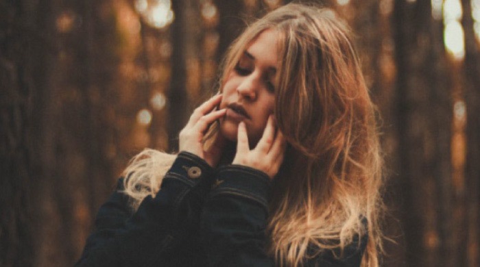 brown haired girl holding her jaw because of sensitive teeth