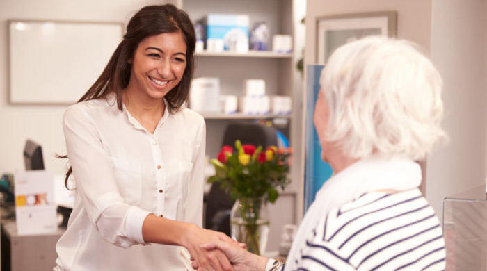 dental assistant welcomes a patient at the dental office