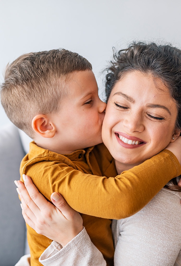 little boy kissing mom on the cheek