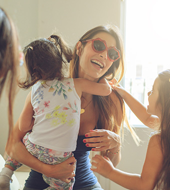 mom with sunglasses holding daughter