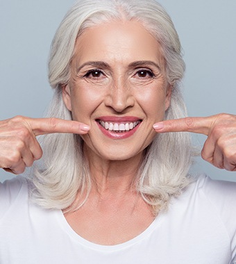 older lady pointing to her smile