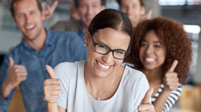 group of young adults give thumbs up to dental sealants for adults