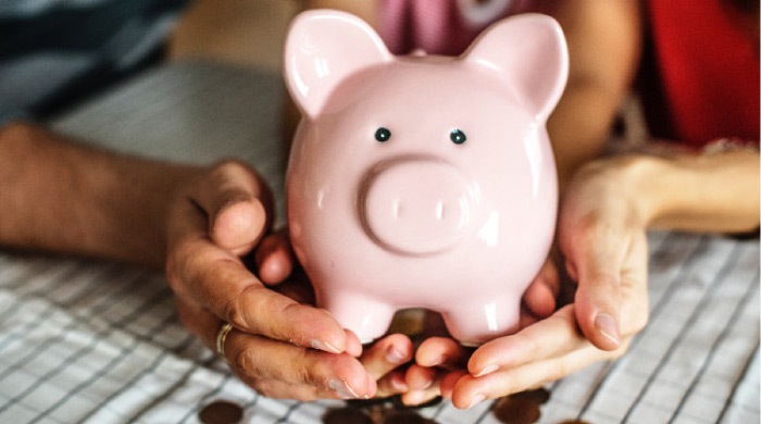 pink piggy bank spilling out coins