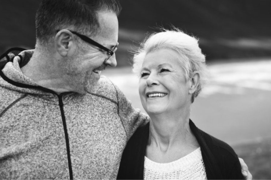 senior couple smile at each other after learning about dental bridges