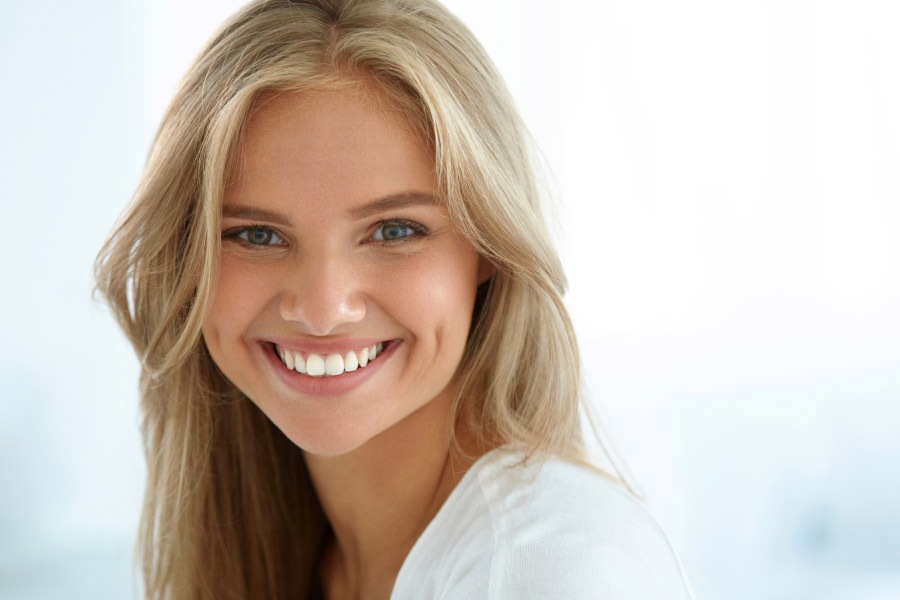 young woman smiles showing off her white teeth