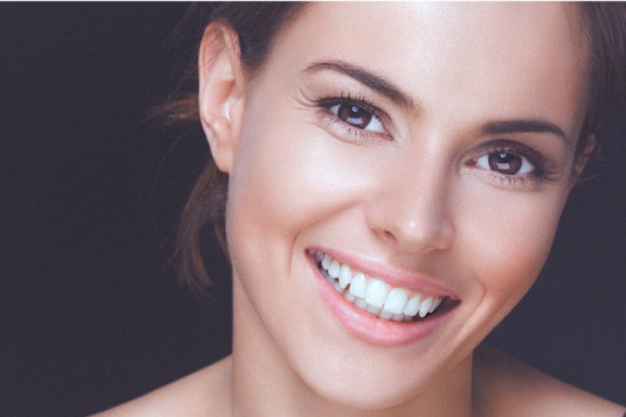 woman flashes a big smile showing off her porcelain veneers