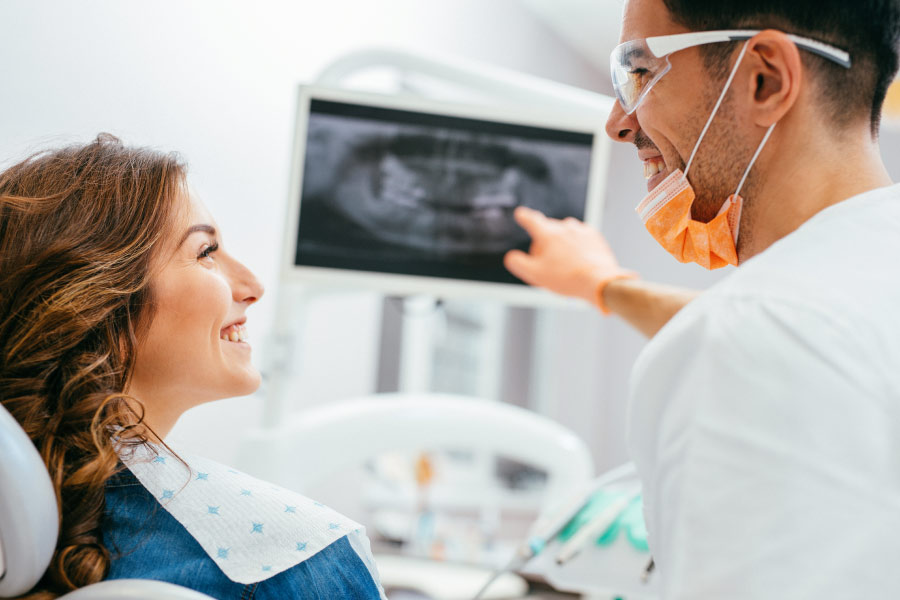 dentist and patient look at a digital x-ray to detect tooth decay